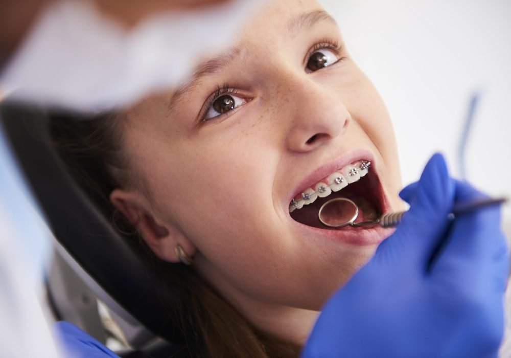 Girl with braces during a routine, dental examination Girl with braces during a routine, dental examination